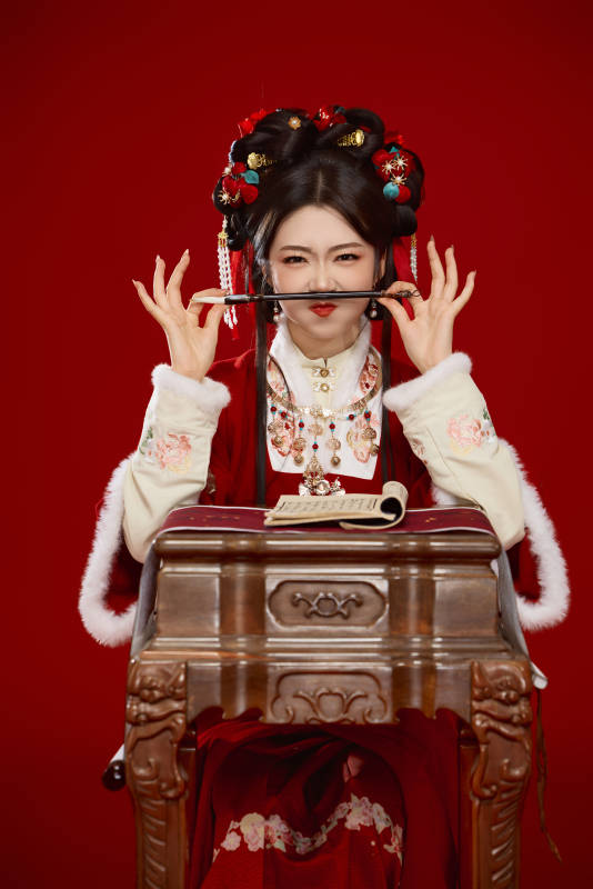 红色背景下身穿喜庆汉服认真学习的中国美女图片