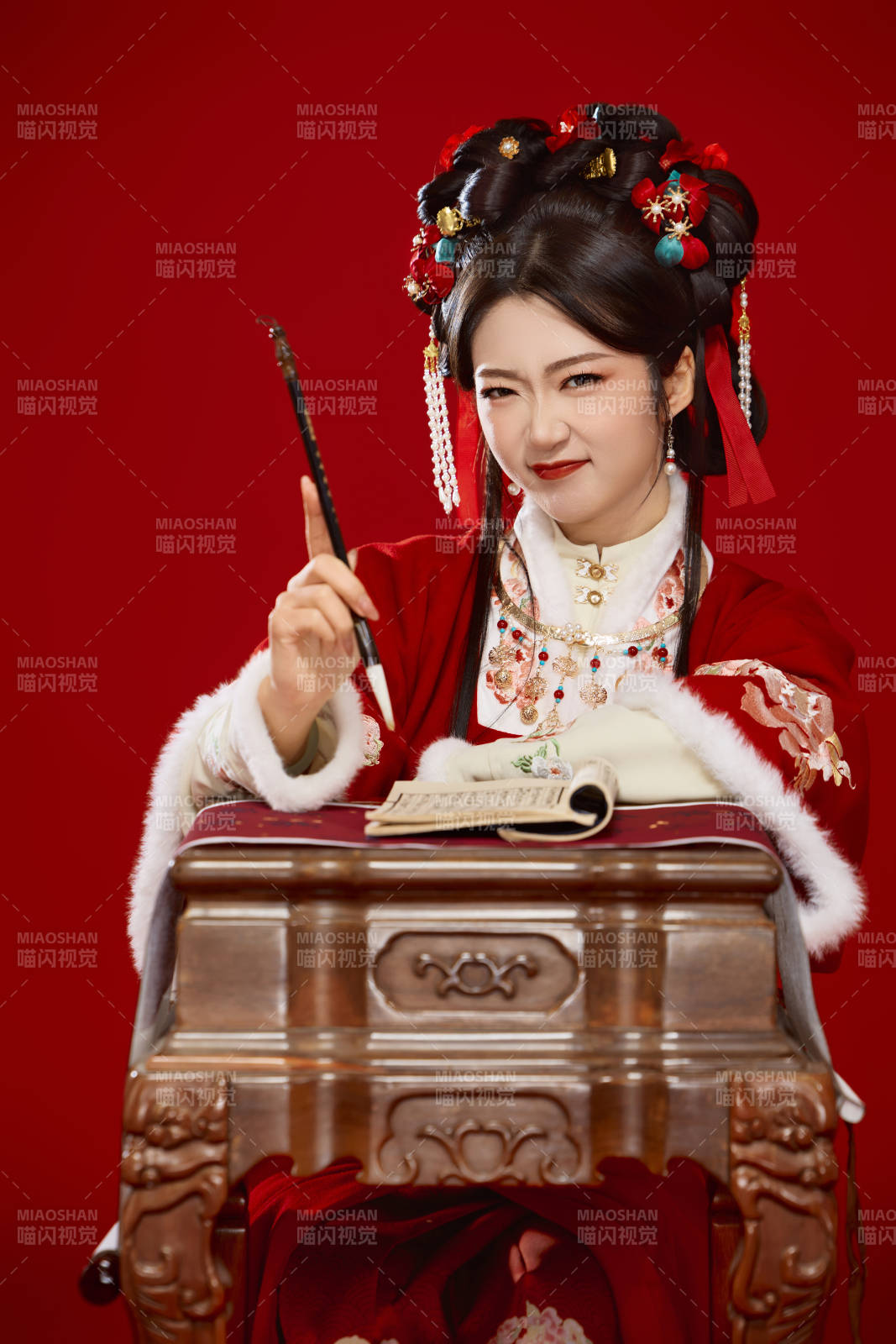 红色背景下身穿喜庆汉服认真学习的中国美女图片