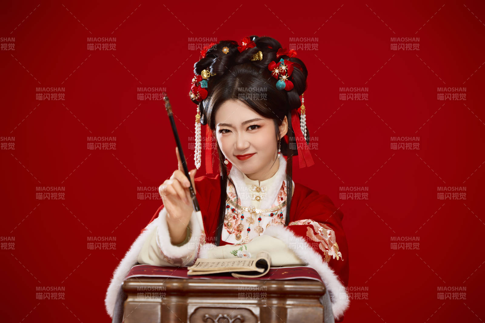 红色背景下身穿喜庆汉服认真学习的中国美女图片