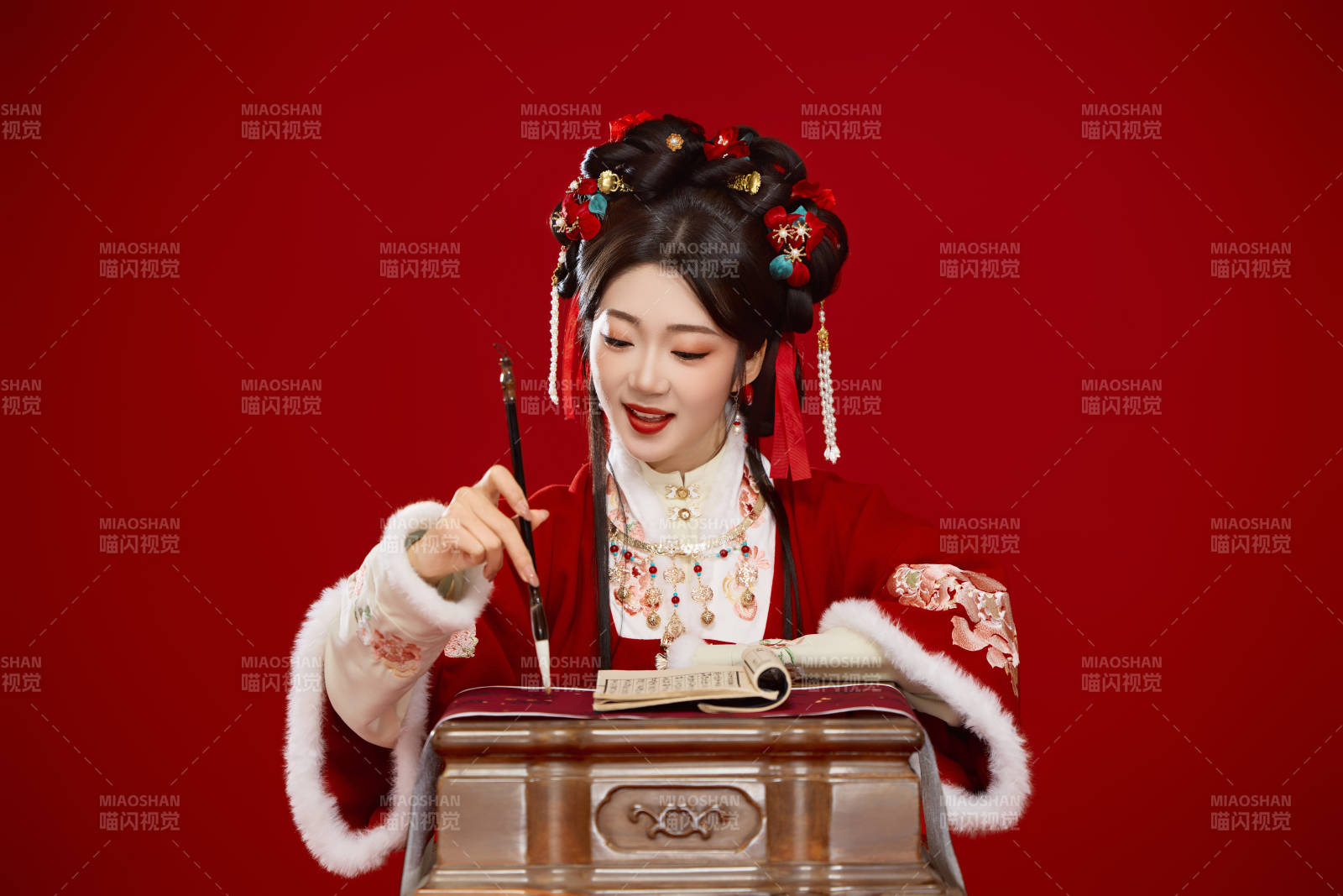 红色背景下身穿喜庆汉服认真学习的中国美女图片