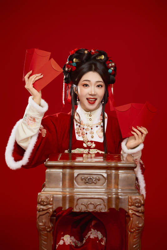 红色背景下身穿汉服手拿红包拜年的中国美女图片