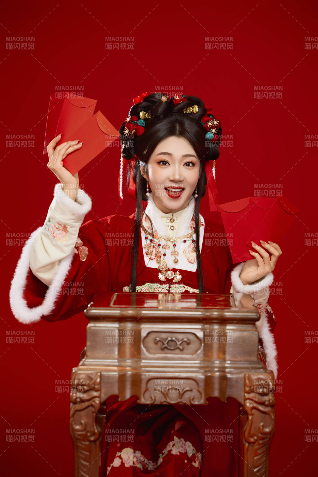 红色背景下身穿汉服手拿红包拜年的中国美女图片