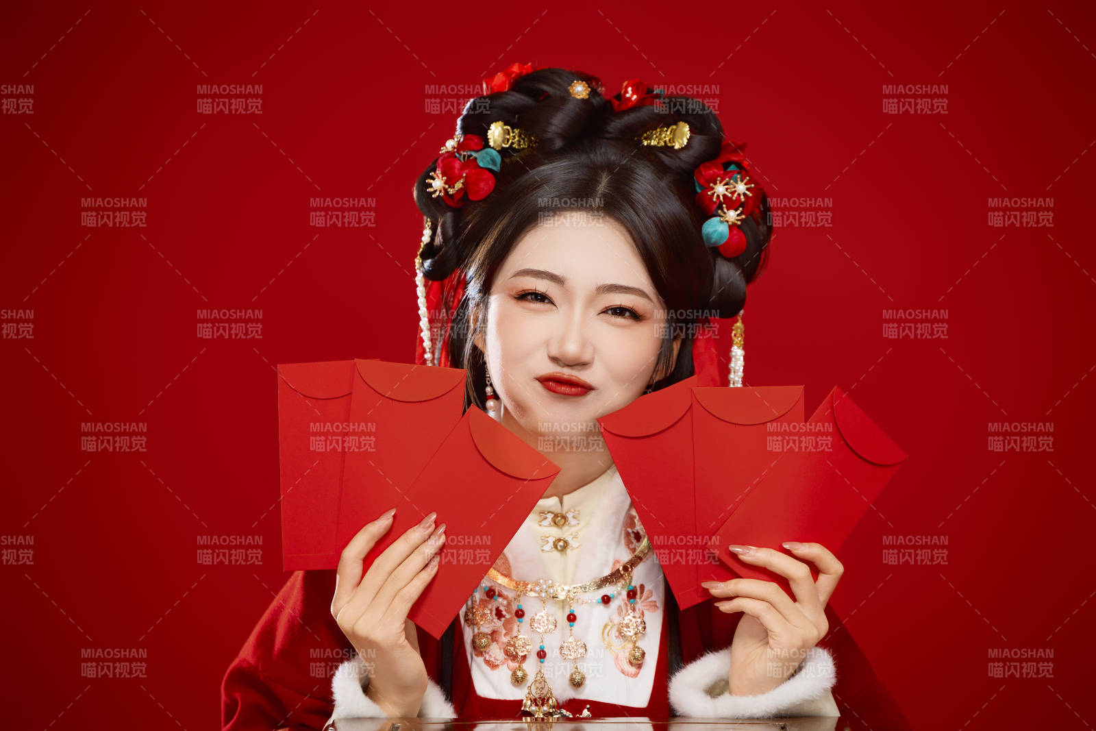 红色背景下身穿汉服手拿红包拜年的中国美女图片