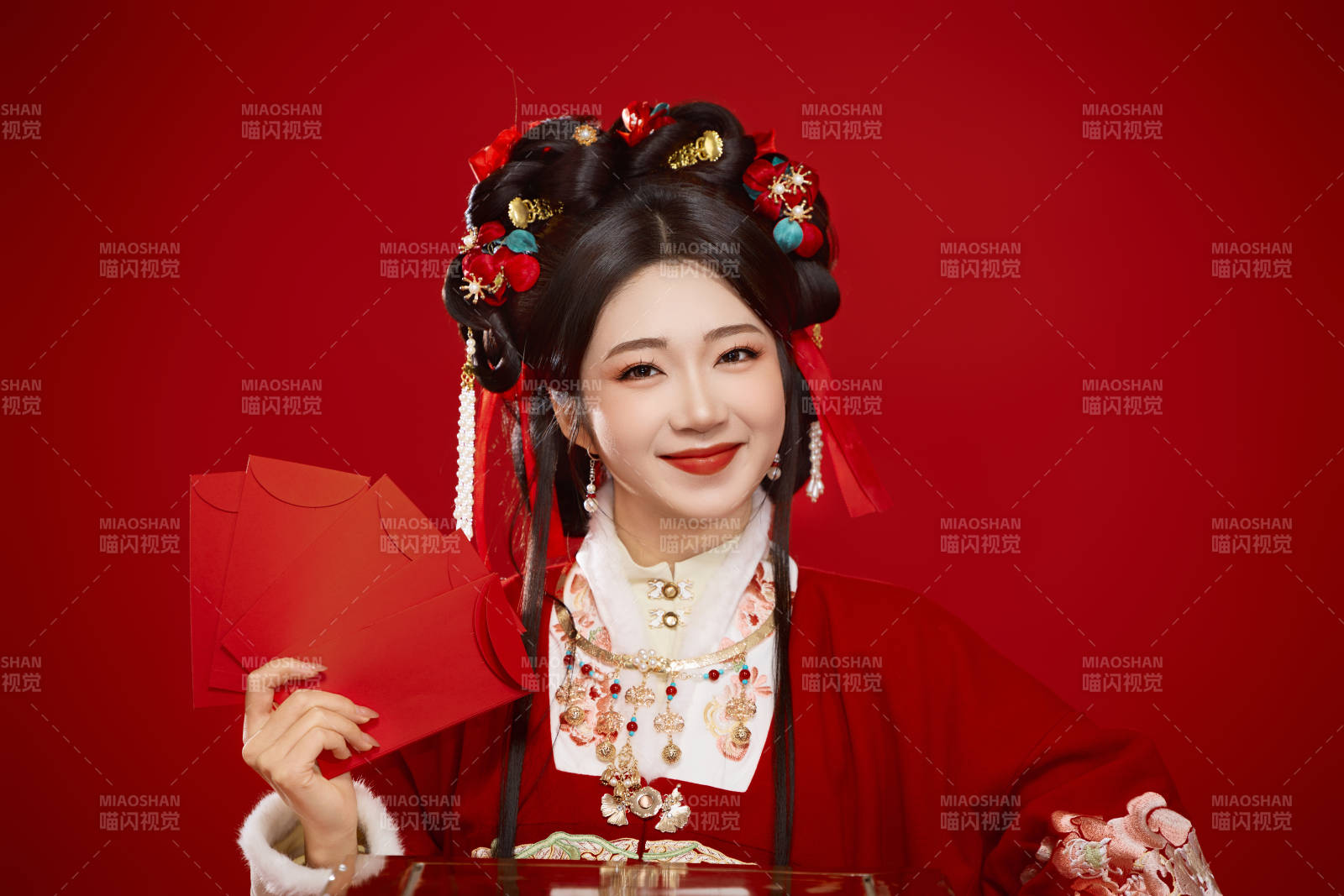 红色背景下身穿汉服手拿红包拜年的中国美女图片