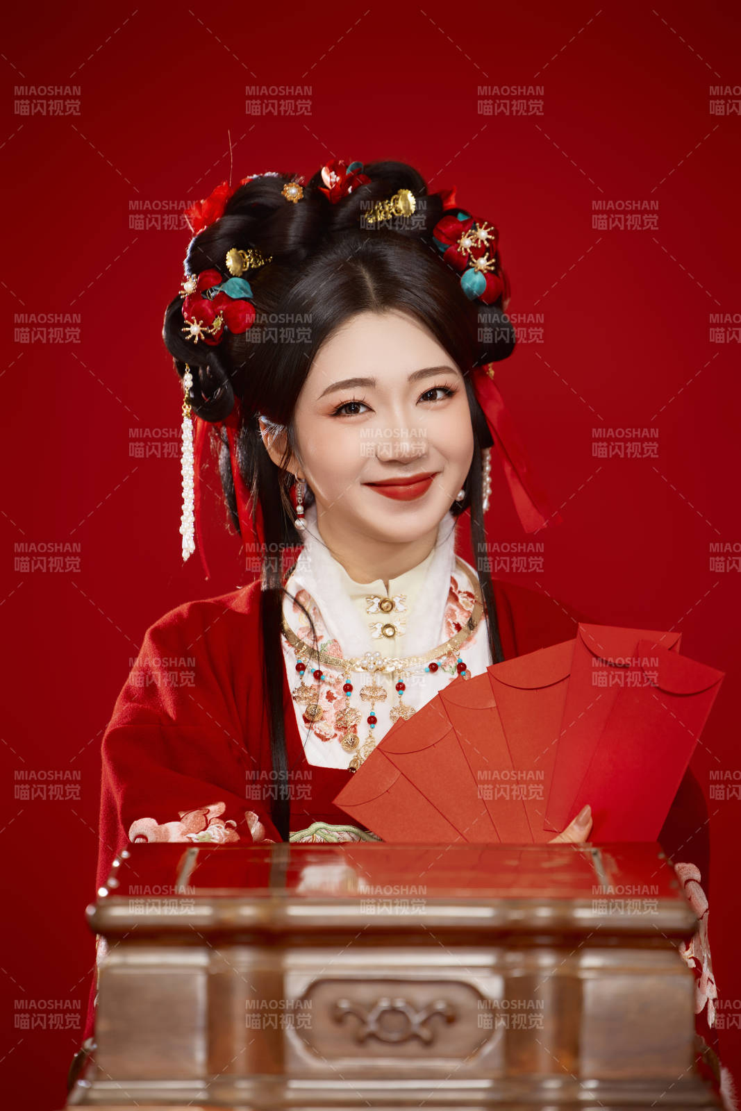红色背景下身穿汉服手拿红包拜年的中国美女图片