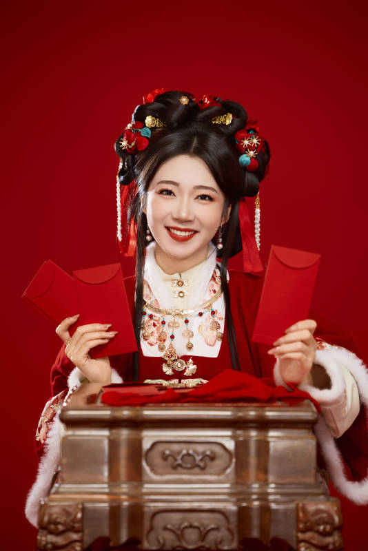 红色背景下身穿汉服手拿红包拜年的中国美女图片