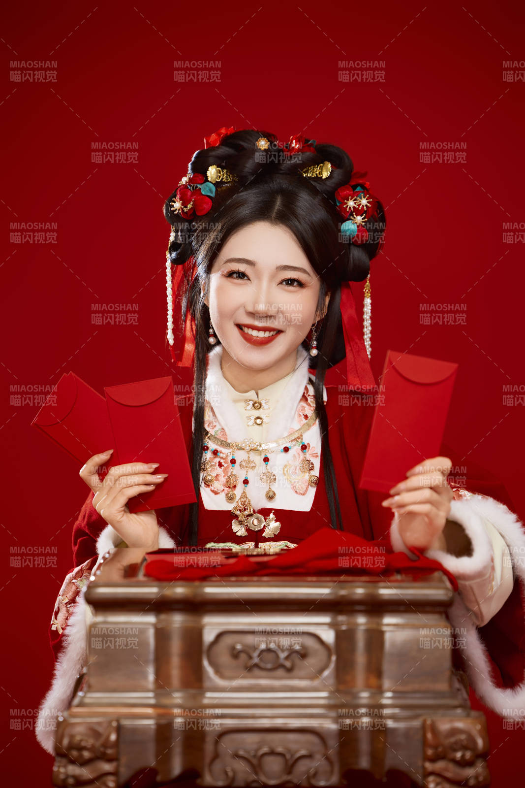红色背景下身穿汉服手拿红包拜年的中国美女图片