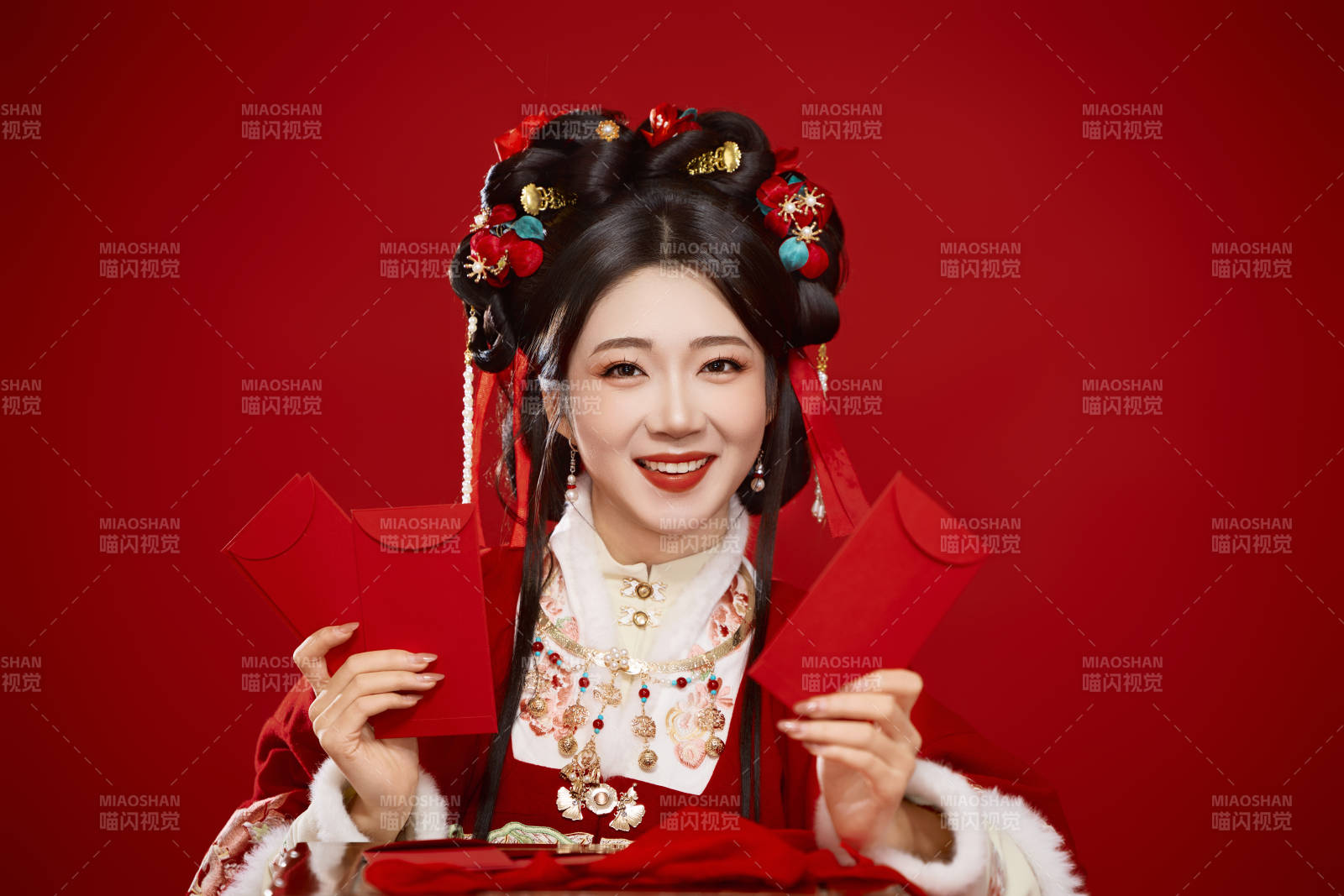 红色背景下身穿汉服手拿红包拜年的中国美女图片