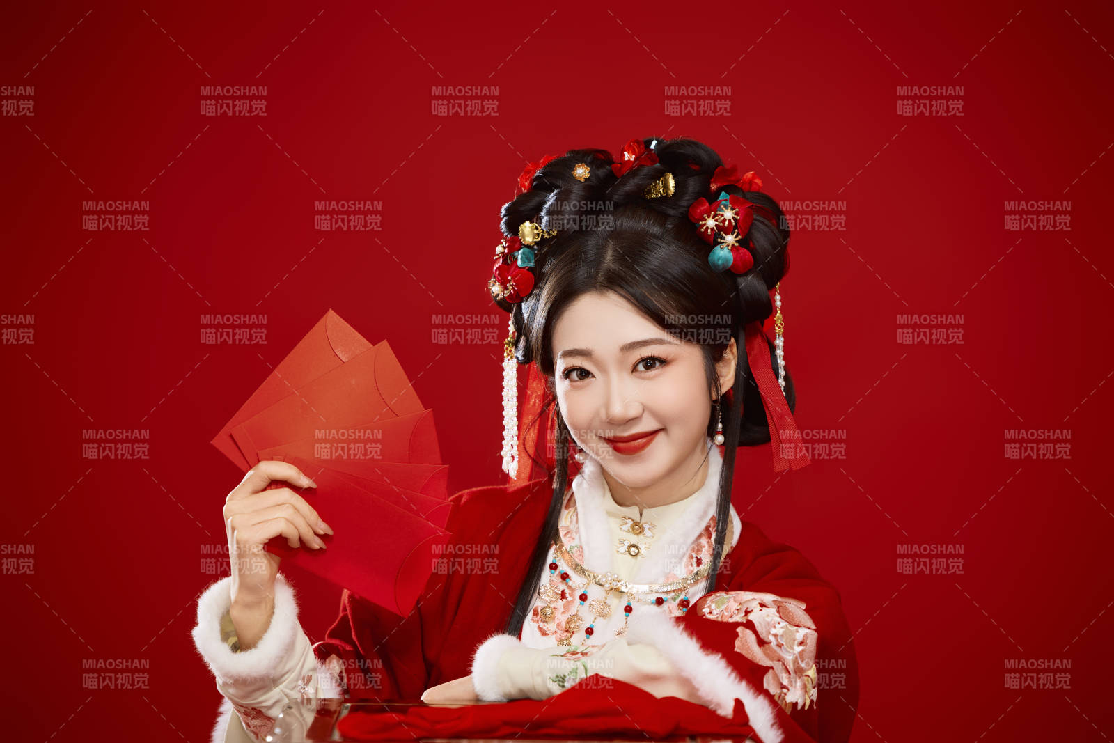 红色背景下身穿汉服手拿红包拜年的中国美女图片