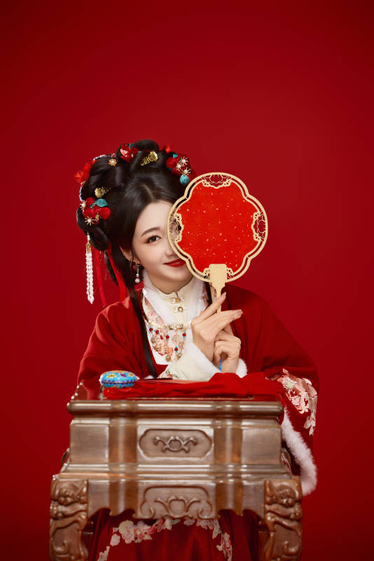 喜庆红色背景下身穿中国汉服的年轻女性图片