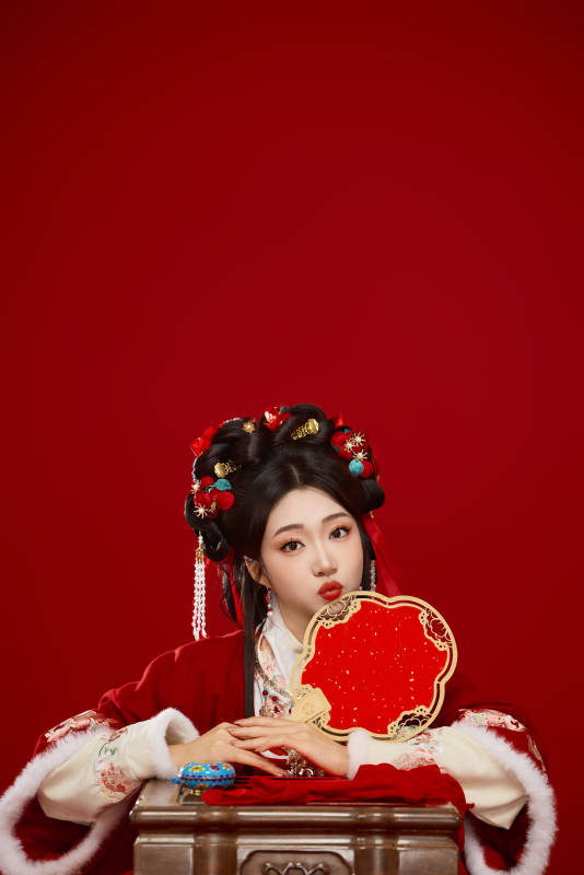 喜庆红色背景下身穿中国汉服的年轻女性图片