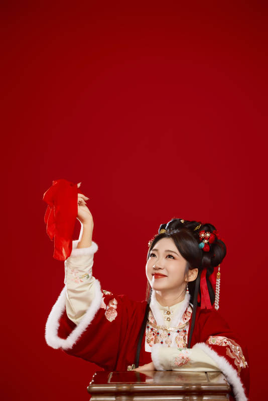 喜庆红色背景下身穿中国汉服的年轻女性图片