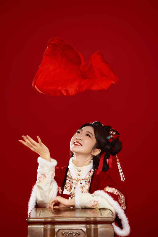 喜庆红色背景下身穿中国汉服的年轻女性图片