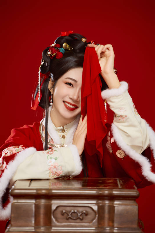 喜庆红色背景下身穿中国汉服的年轻女性图片