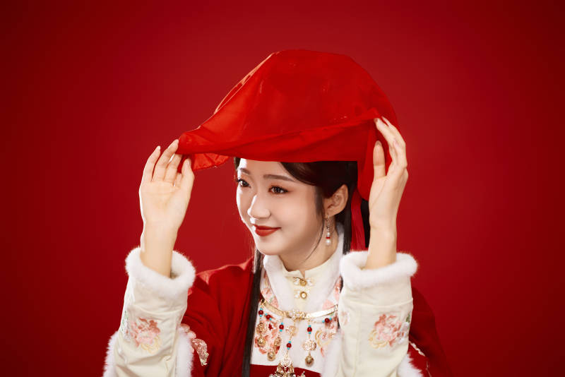 喜庆红色背景下身穿中国汉服的年轻女性图片