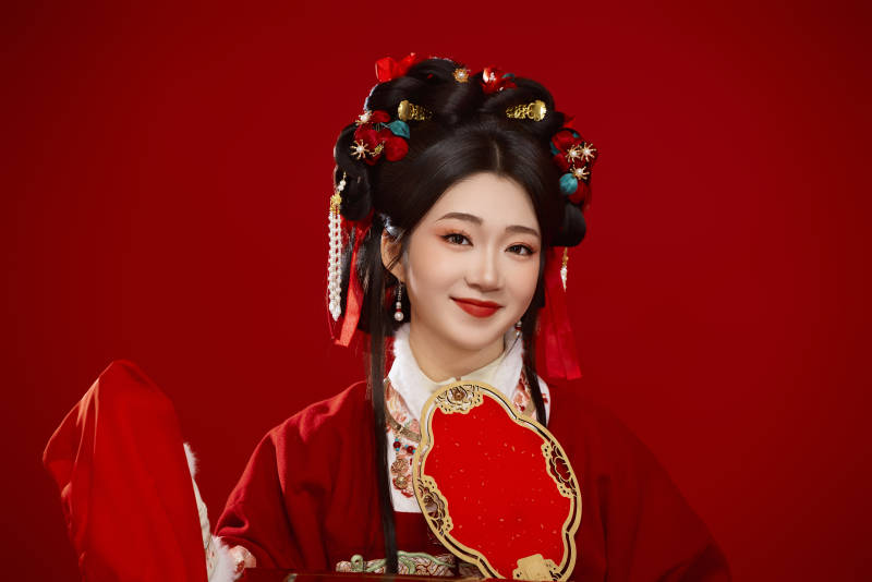 喜庆红色背景下身穿中国汉服的年轻女性图片