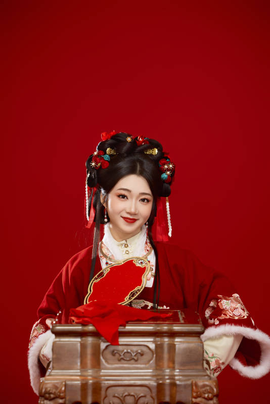 喜庆红色背景下身穿中国汉服的年轻女性图片