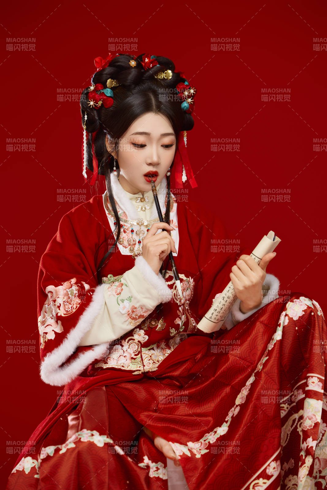 红色背景下身穿喜庆汉服认真学习的中国美女图片