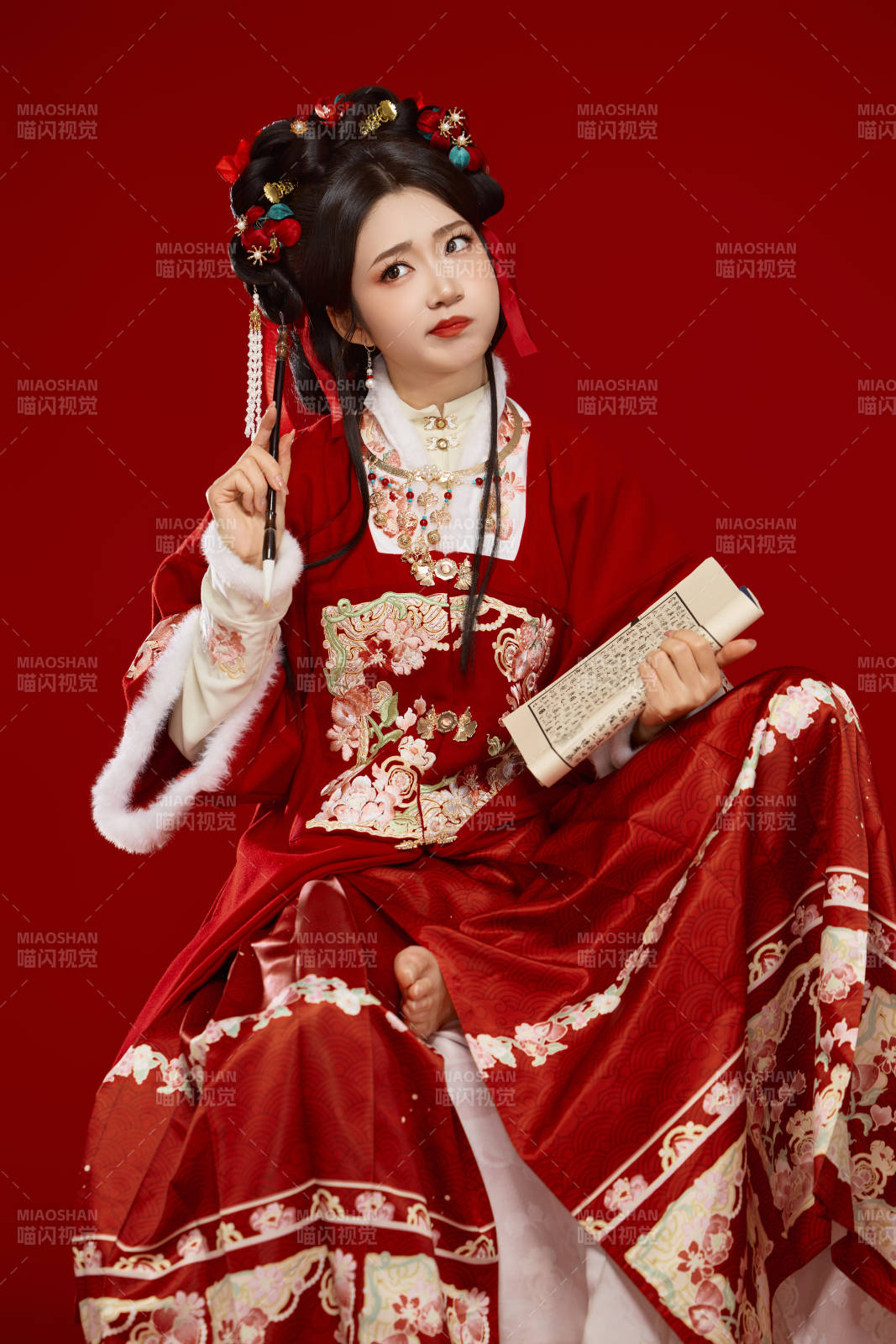 红色背景下身穿喜庆汉服认真学习的中国美女图片