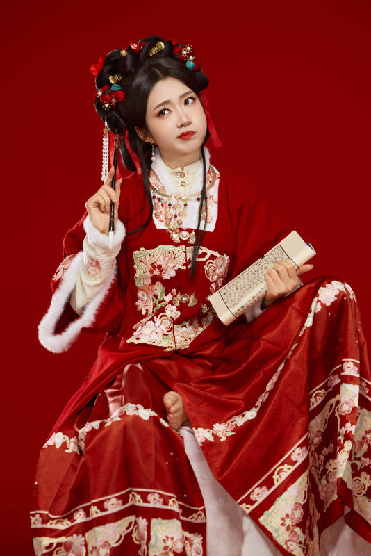 红色背景下身穿喜庆汉服认真学习的中国美女图片