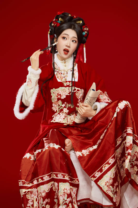 红色背景下身穿喜庆汉服认真学习的中国美女图片