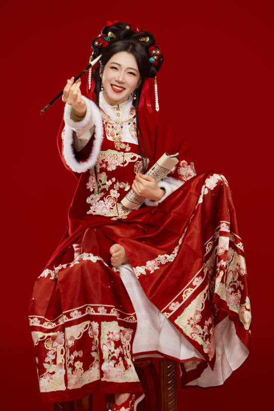 红色背景下身穿喜庆汉服认真学习的中国美女图片