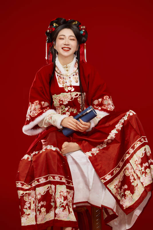 红色背景下身穿喜庆汉服认真学习的中国美女图片