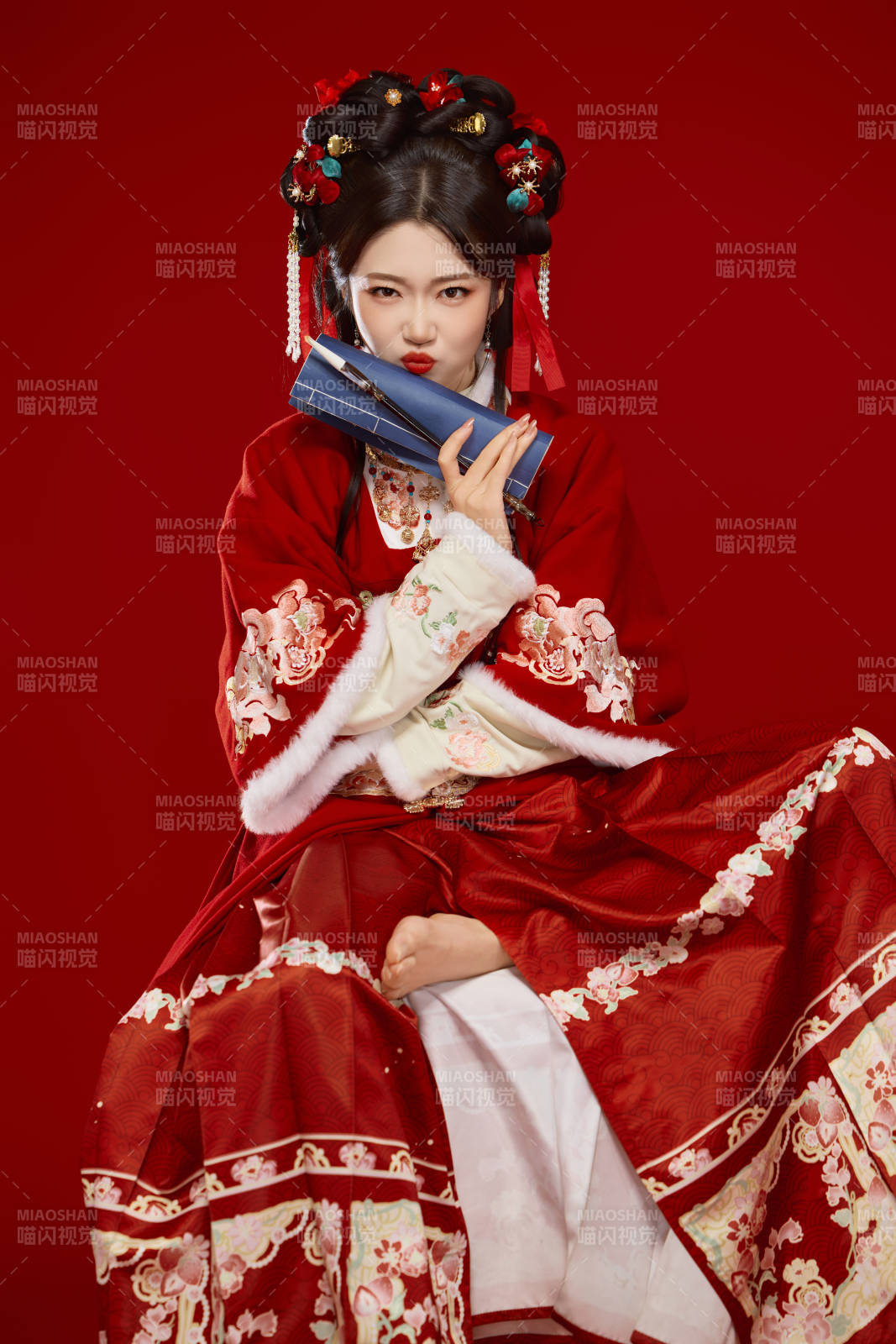 红色背景下身穿喜庆汉服认真学习的中国美女图片