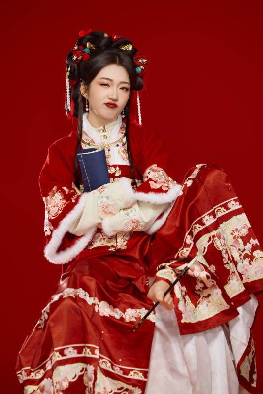 红色背景下身穿喜庆汉服认真学习的中国美女图片