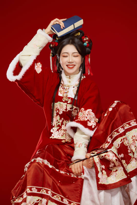 红色背景下身穿喜庆汉服认真学习的中国美女图片