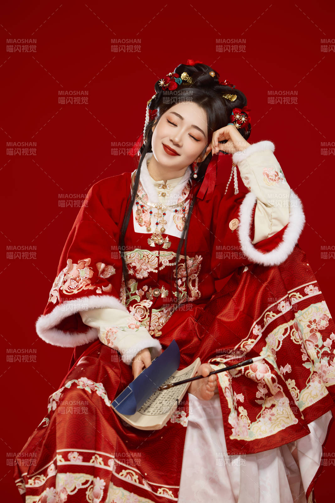 红色背景下身穿喜庆汉服认真学习的中国美女图片