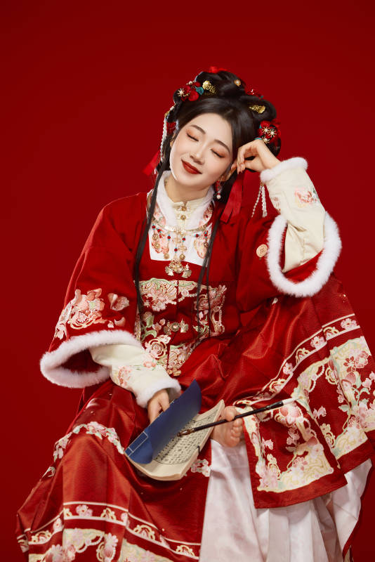 红色背景下身穿喜庆汉服认真学习的中国美女图片