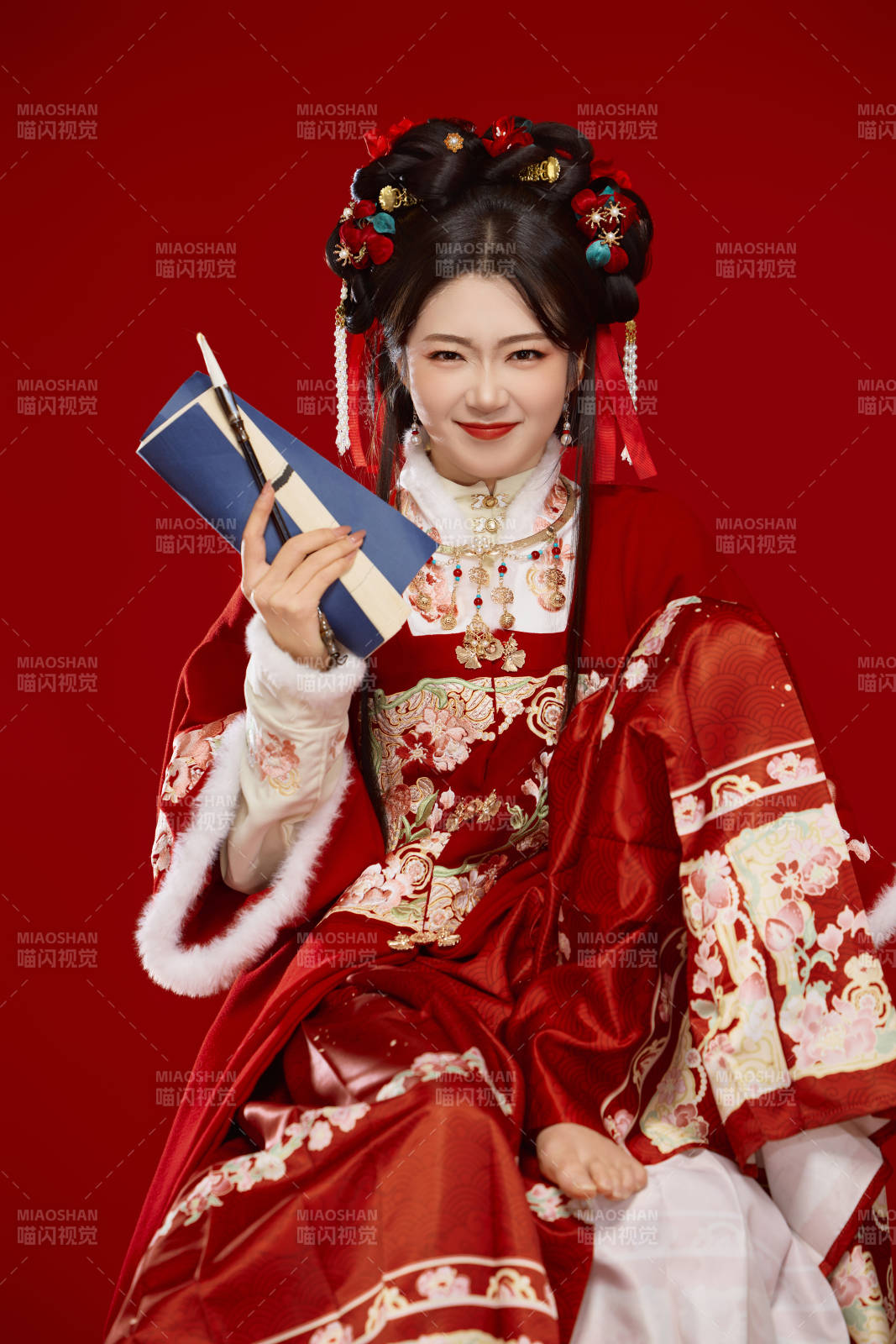 红色背景下身穿喜庆汉服认真学习的中国美女图片