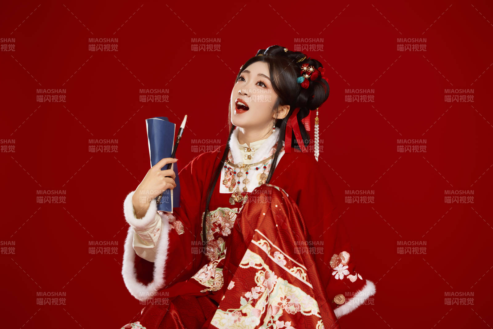 红色背景下身穿喜庆汉服认真学习的中国美女图片