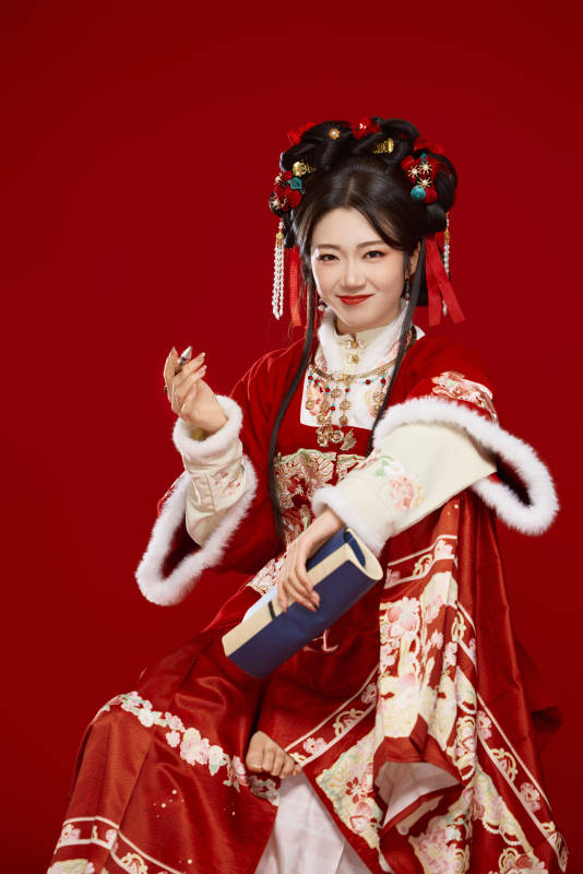 红色背景下身穿喜庆汉服认真学习的中国美女图片