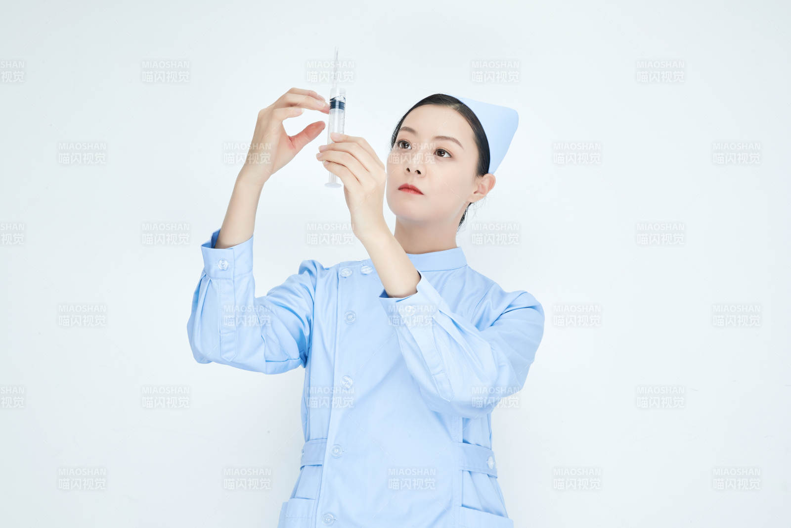 穿护士服戴口罩手执针筒的年轻女护士图片