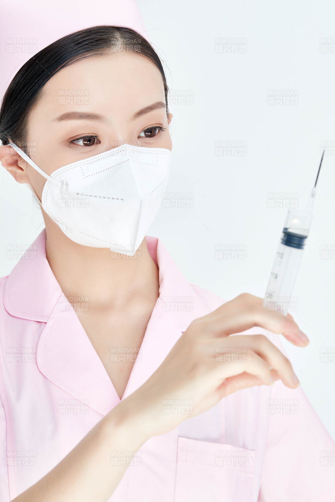 穿护士服戴口罩手执针筒的年轻女护士图片