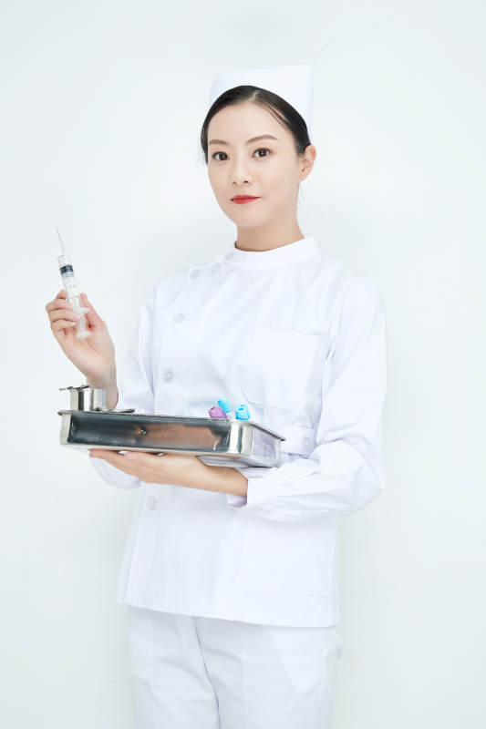 身穿护士服手抱化验托盘的年轻女护士图片