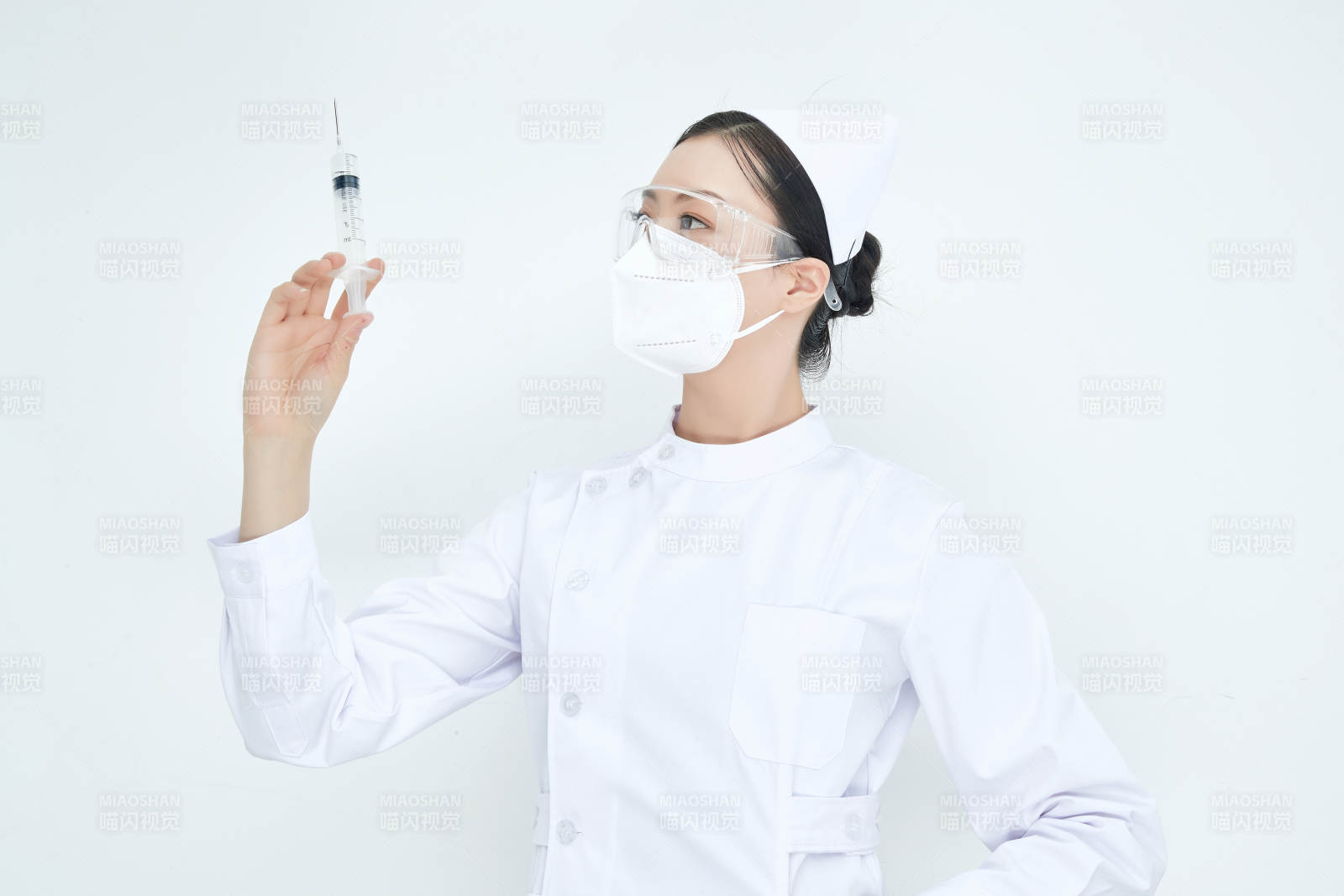 穿护士服戴口罩手执针筒的年轻女护士图片