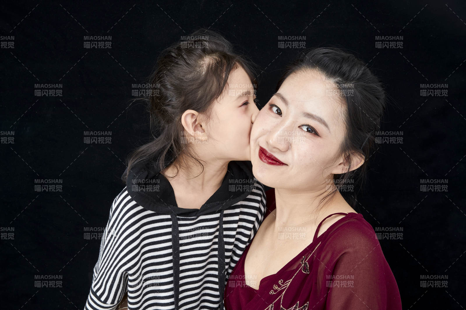 黑色背景的美丽妈妈与可爱女儿亲子人像图片