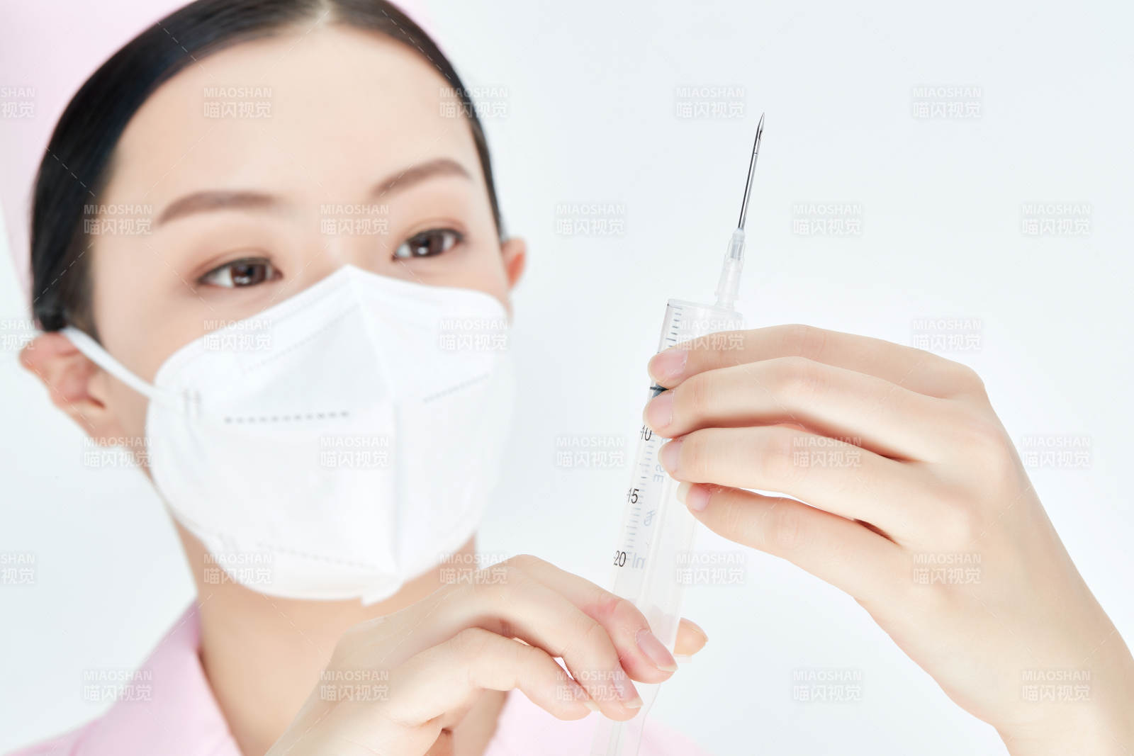 穿护士服戴口罩手执针筒的年轻女护士图片