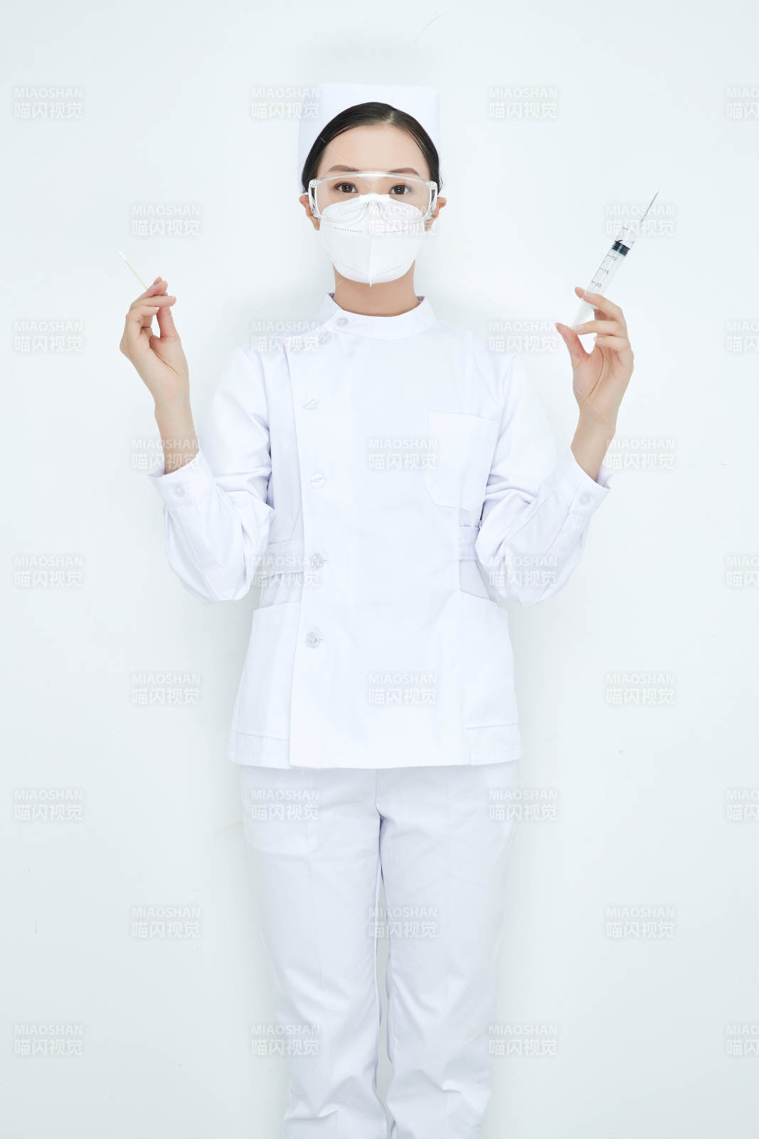 穿护士服戴口罩手执针筒的年轻女护士图片