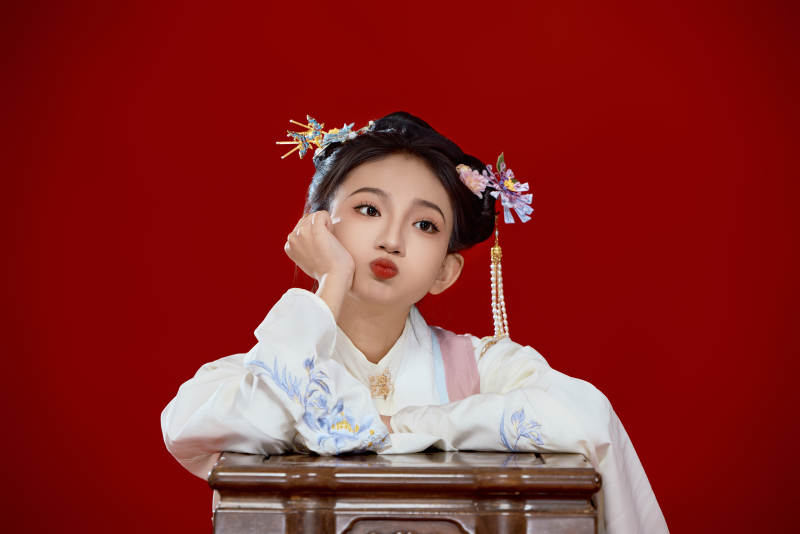 红色背景下穿着中国明朝明制汉服服饰的少女图片