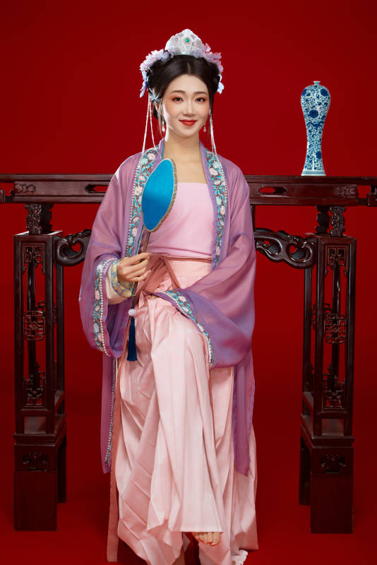 红色背景下身穿中国明朝簪花发饰汉服的美女图片