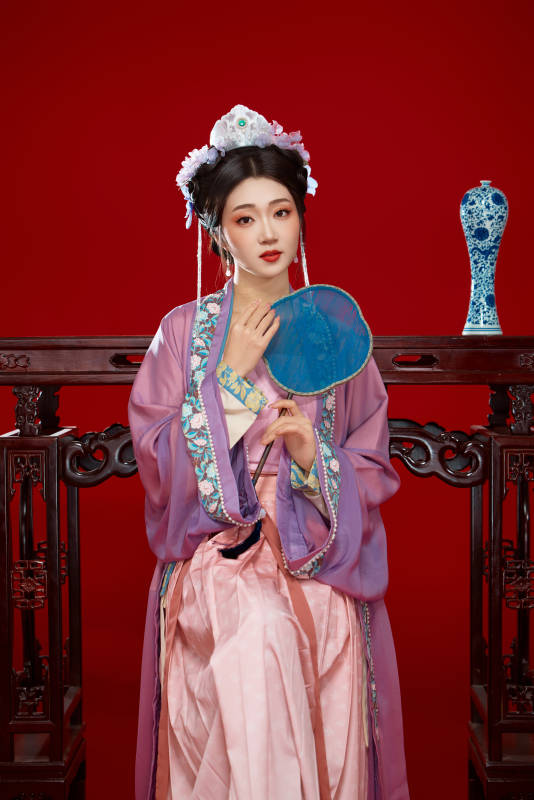 红色背景下身穿中国明朝簪花发饰汉服的美女图片