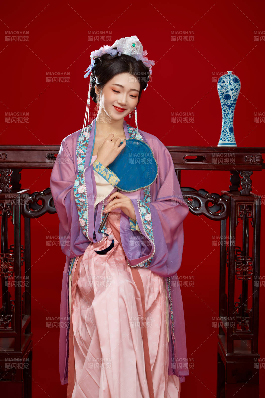 红色背景下身穿中国明朝簪花发饰汉服的美女图片