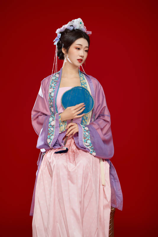 红色背景下身穿中国明朝簪花发饰汉服的美女图片