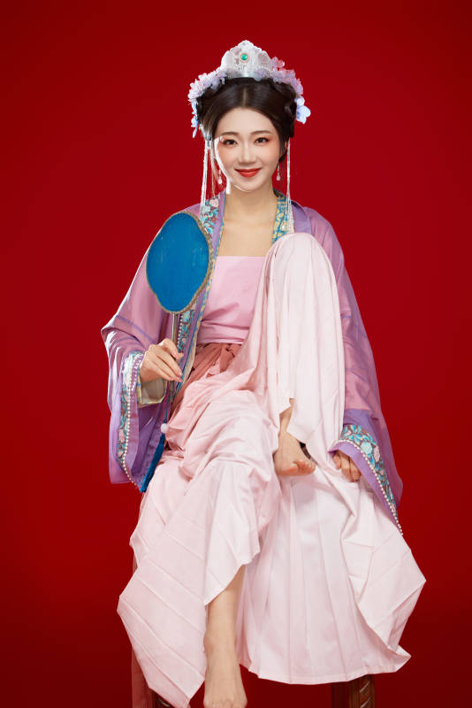 红色背景下身穿中国明朝簪花发饰汉服的美女图片