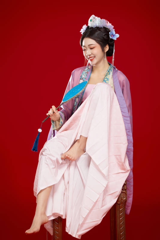 红色背景下身穿中国明朝簪花发饰汉服的美女图片