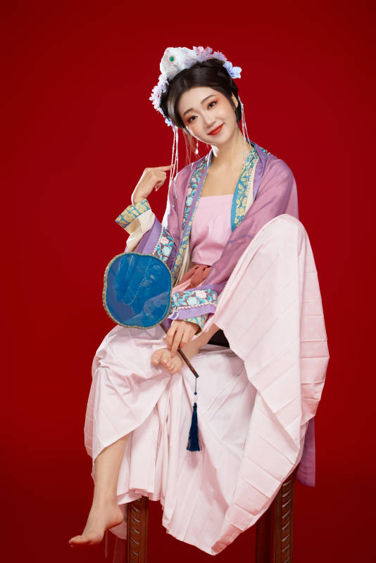 红色背景下身穿中国明朝簪花发饰汉服的美女图片